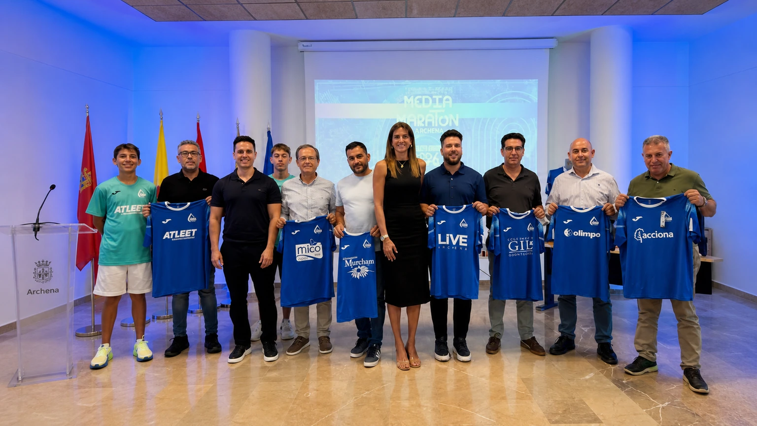 Presentación oficial de la Media Maratón de Archena con organizadores y camisetas deportivas completas en formato 16:9