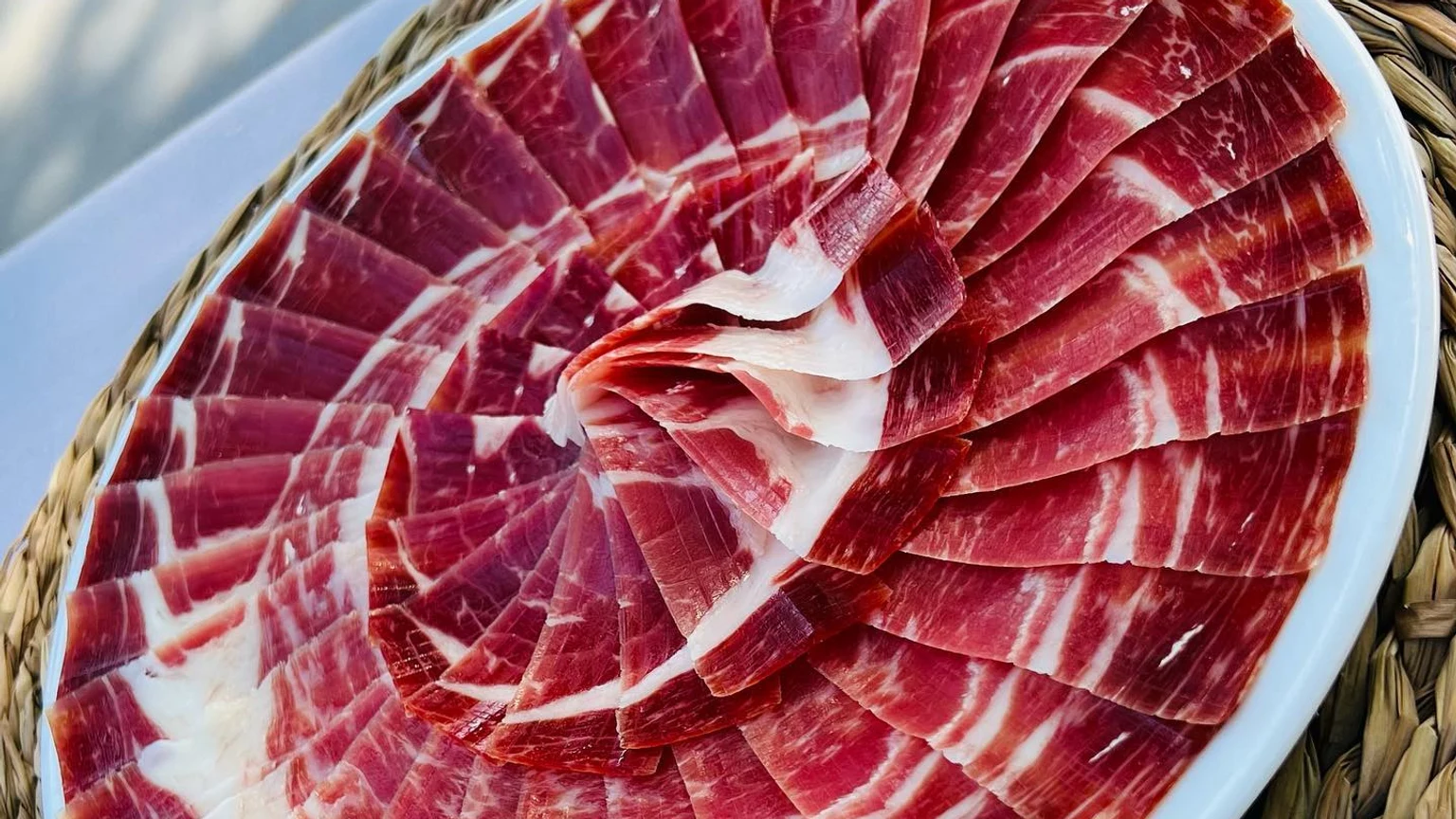 Plato de jamón cortado en lonchas finas como ejemplo de presentación tradicional española
