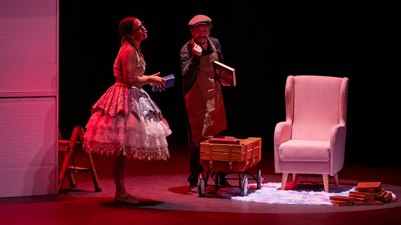 Dos intérpretes representan Hay que salvar los libros sobre un escenario con varios ejemplares en la escenografía