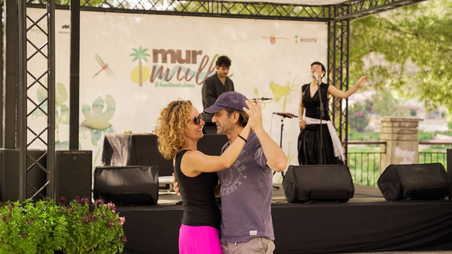 Dos asistentes bailan ante el escenario del Festival Murmullo en Villanueva del Río Segura