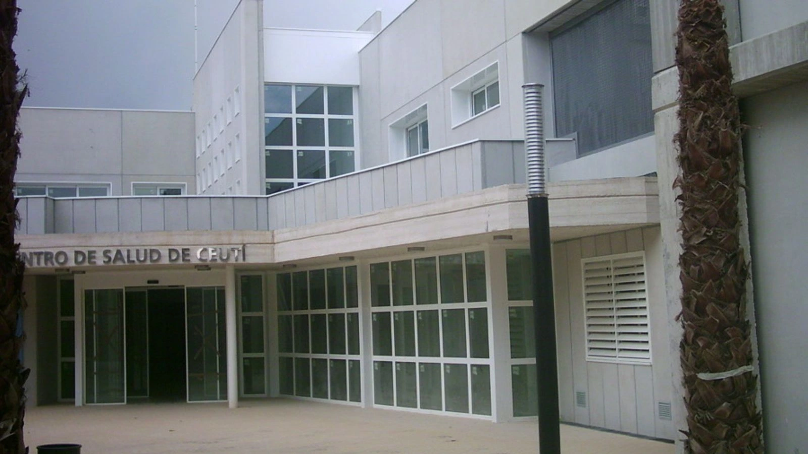 Acceso acristalado al Centro de Salud de Ceutí, entre las fachadas blancas del edificio