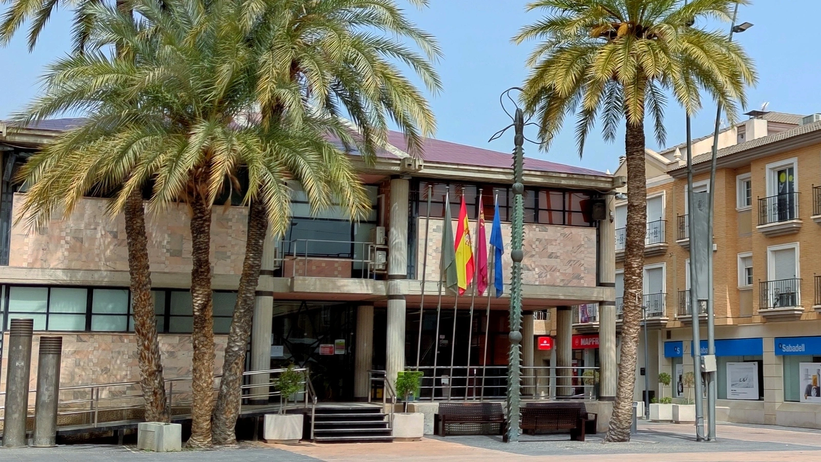 Fachada del Ayuntamiento de Ceutí con su acceso y las banderas, en una fotografía de archivo