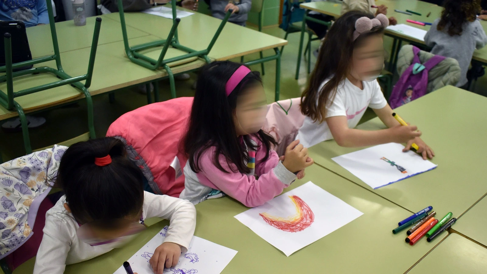 Menores dibujan en una actividad de Concilia Ocio en el colegio Joaquín Cantero, con los rostros difuminados por la fuente original.