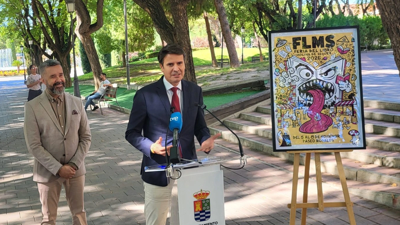 Presentación de la Feria del Libro de Molina junto al cartel de la edición de 2026
