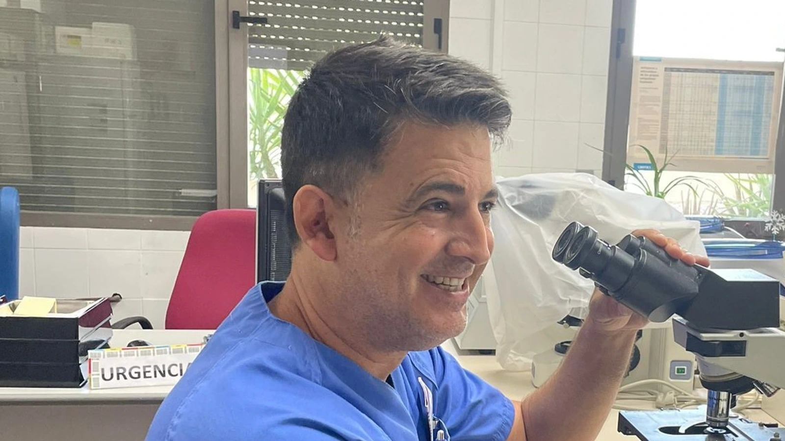 Profesional junto a un microscopio en una imagen difundida con la información sobre el hospital de Cieza.