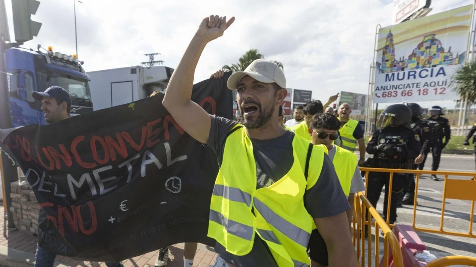 Manifestante con chaleco amarillo y pancarta por el convenio del metal durante las protestas en Murcia
