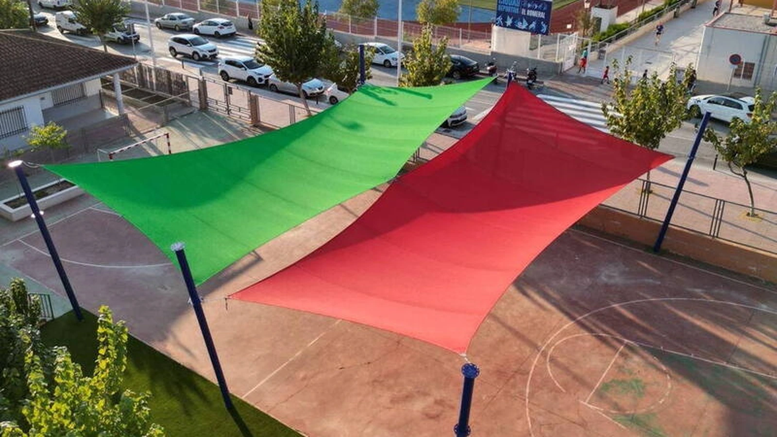 Pista del CEIP Nuestra Señora de Fátima con lonas de sombra verdes y rojas