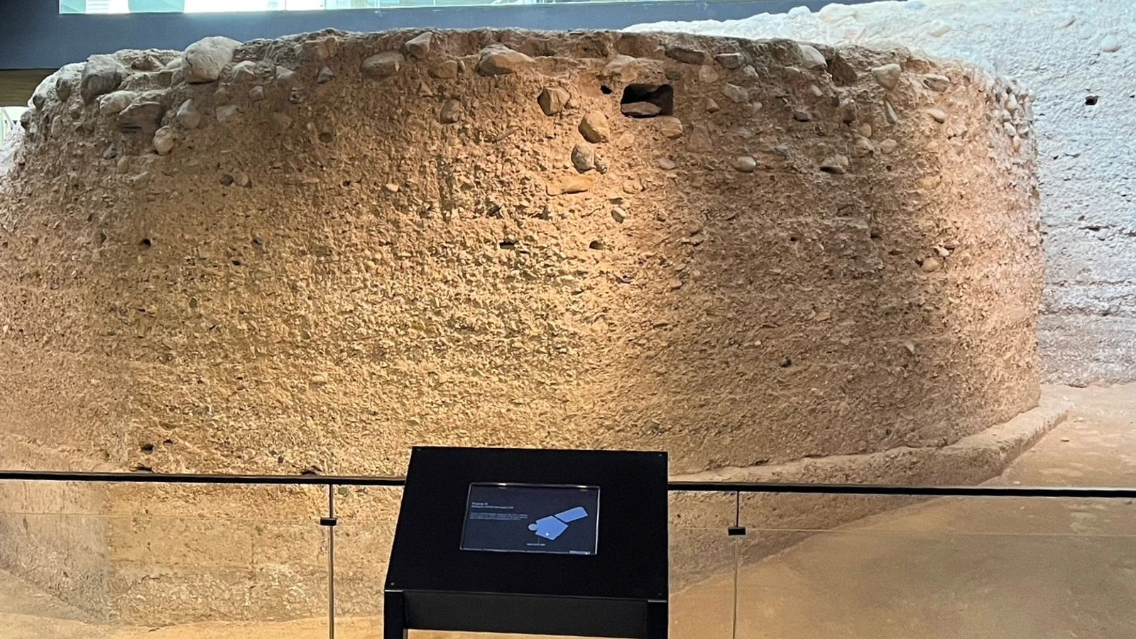 Restos de la torre nonagonal de la muralla medieval de Molina de Segura en el interior del MUDEM, con un atril informativo delante