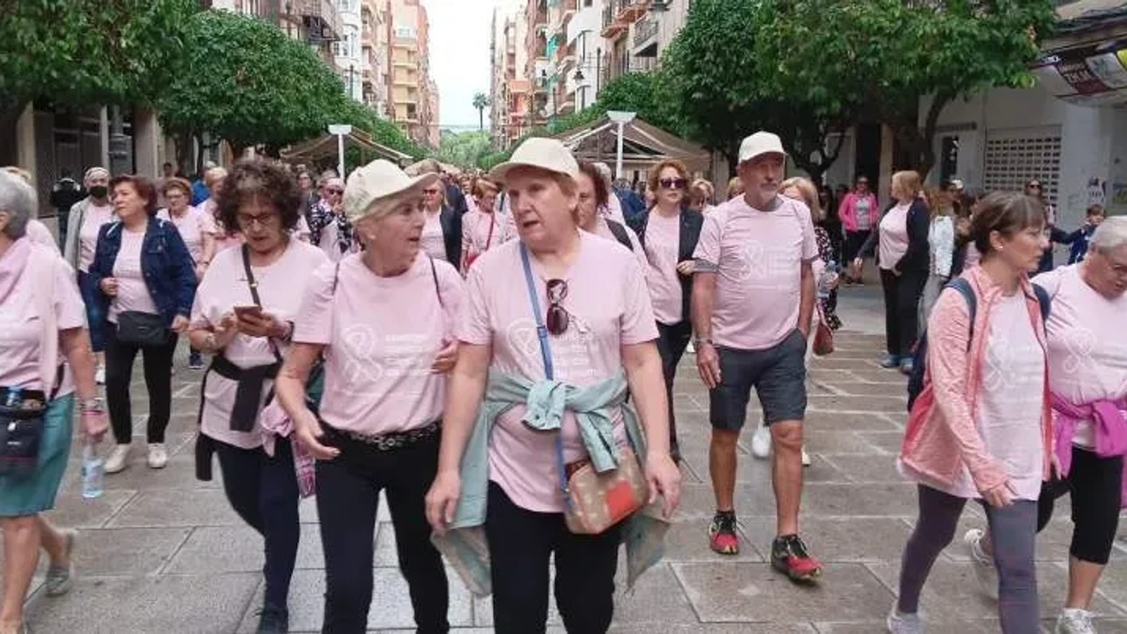Participantes con camisetas rosas caminando por una calle peatonal de Molina de Segura en la marcha de 2023.