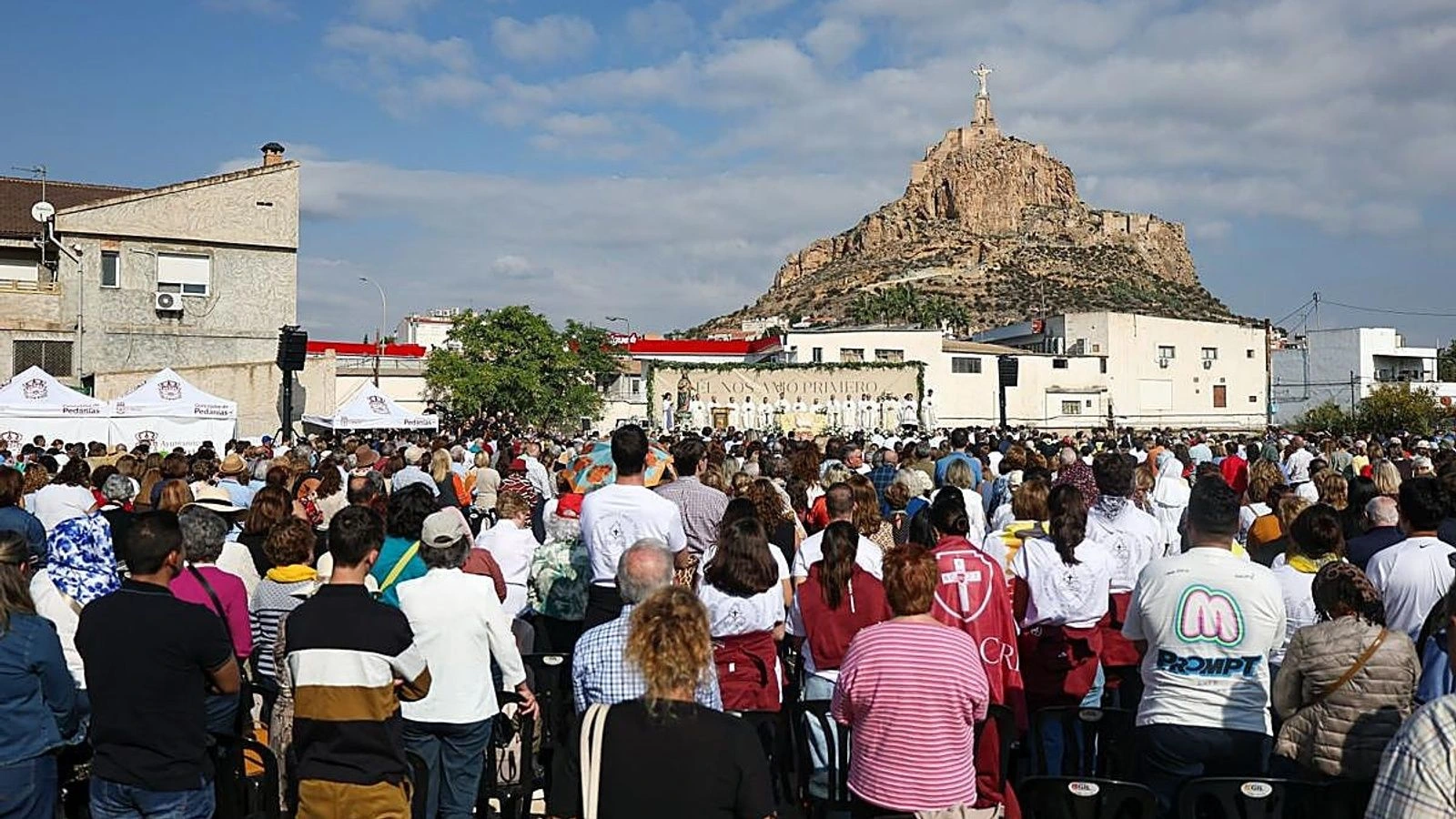 Miles de fieles asisten a la misa del centenario en Monteagudo, con el altar al fondo y el Cristo sobre el cerro.