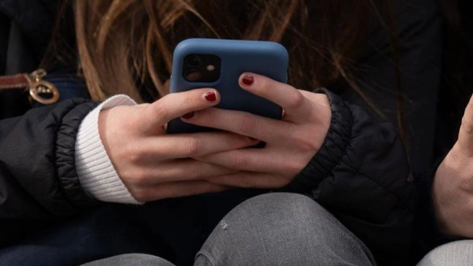 Detalle de unas manos que sostienen un teléfono móvil