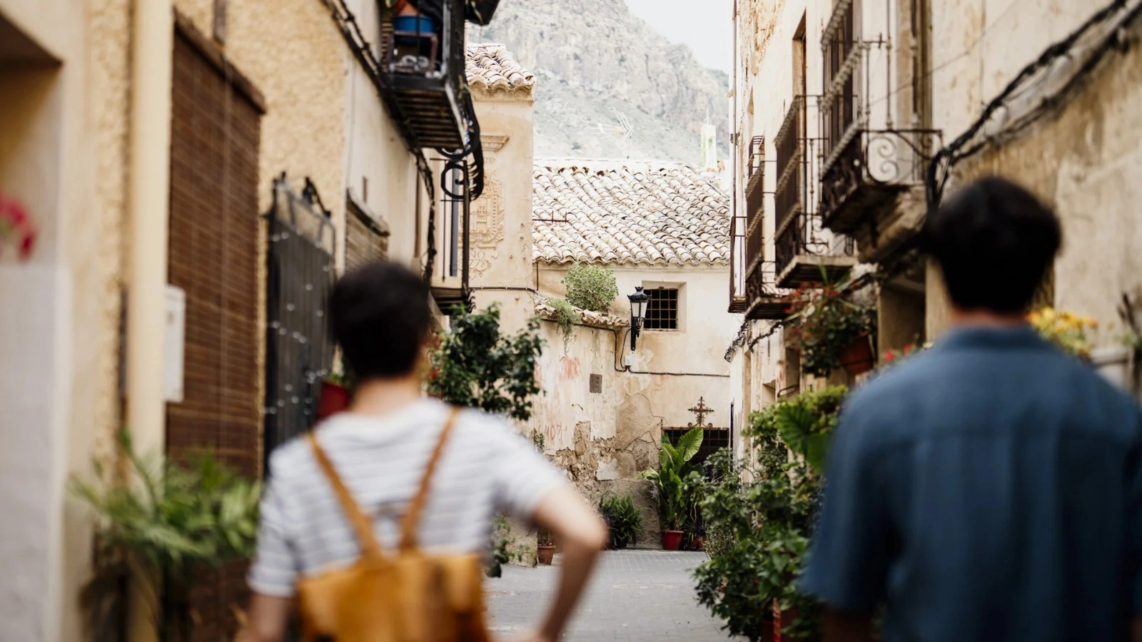 Calle del casco urbano de Ojós, con su arquitectura tradicional y dos visitantes de espaldas