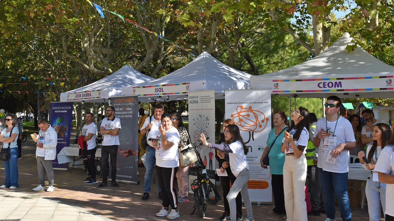 Vecinos y voluntarios junto a las carpas de varias entidades sociales en la primera Participarty, en el parque de la Constitución de Las Torres de Cotillas