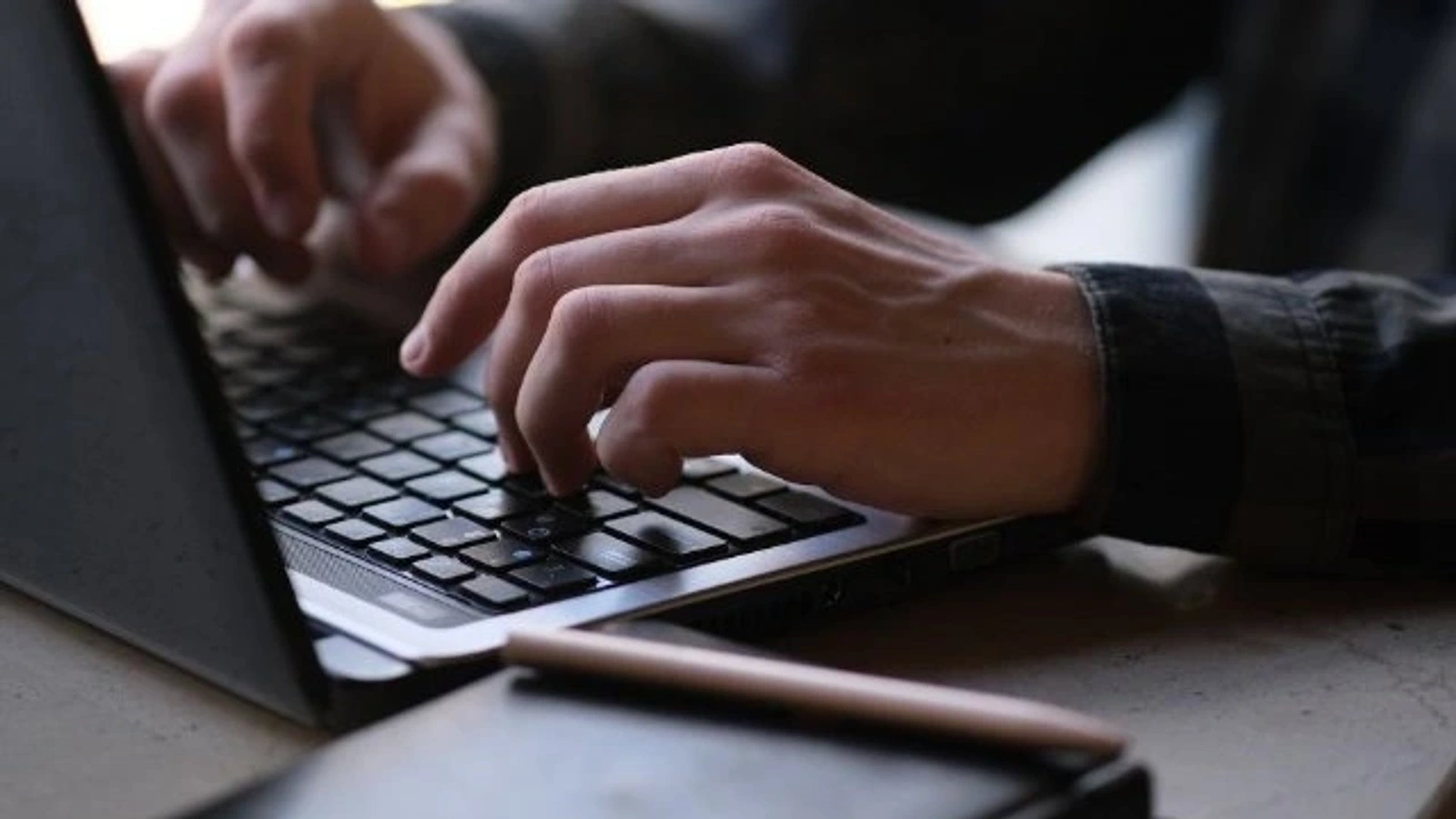 Manos escribiendo en un ordenador portátil, imagen de recurso sobre la tramitación de candidaturas por internet.