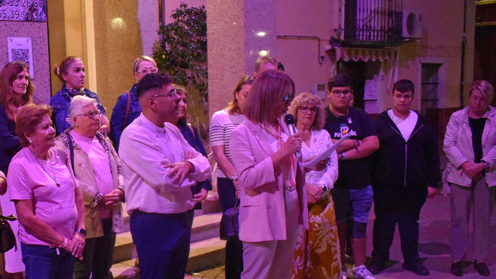 Lectura del manifiesto contra el cáncer de mama en Las Torres de Cotillas, con participantes bajo la iluminación rosa.