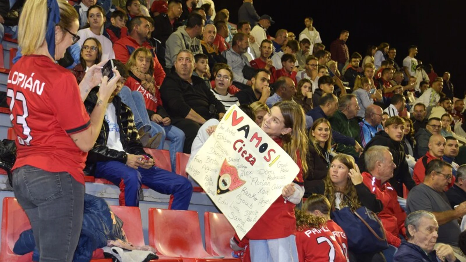 Aficionados del CD Cieza en la grada de La Arboleja durante un partido de fútbol regional.