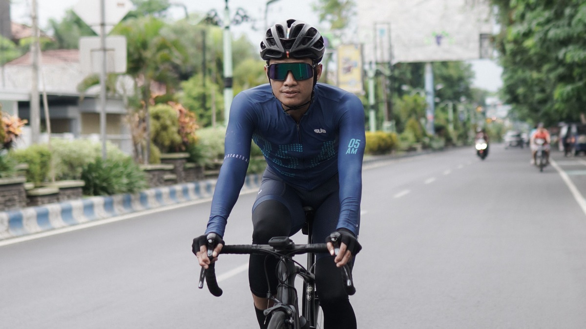 Un ciclista con casco y gafas circula en bicicleta por una calle, en una fotografía de recurso.