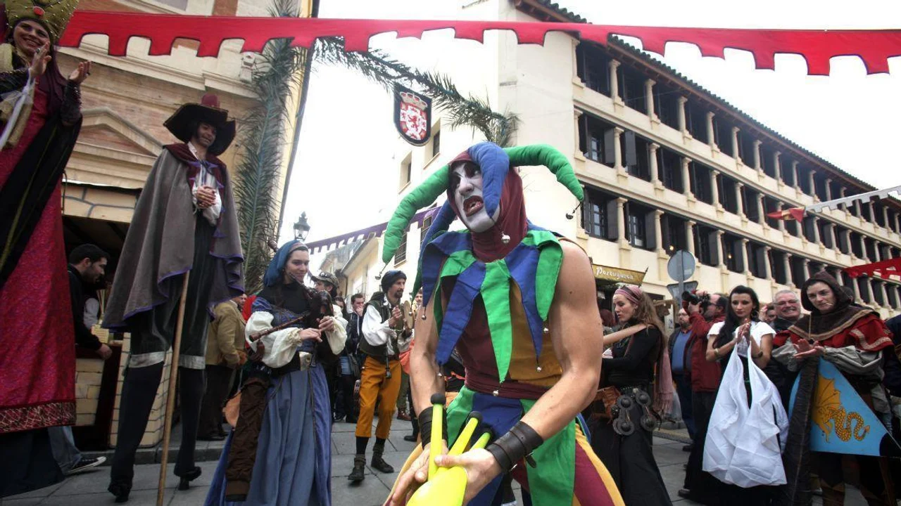 Ambiente de mercado histórico con artistas de calle y público durante una feria temática