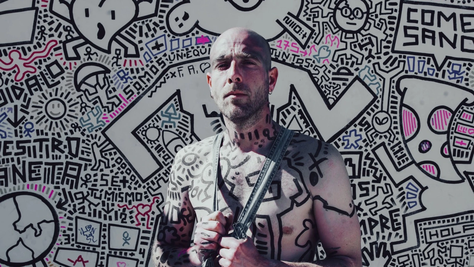 Salvador Marín, El Tipo Raro, delante de una pared cubierta con sus dibujos