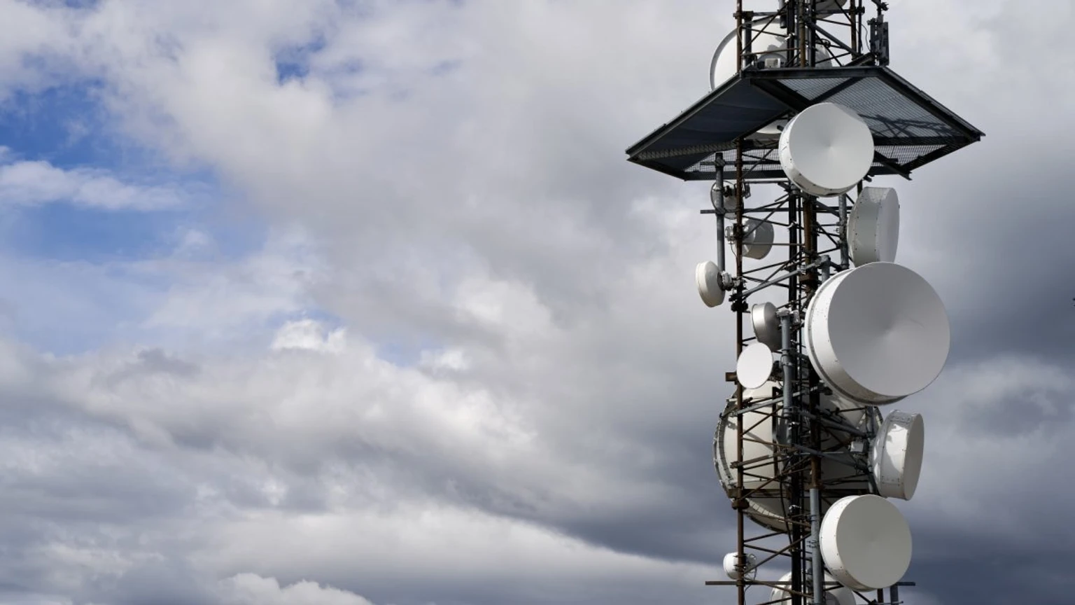 Antena de telecomunicaciones bajo un cielo nublado, en una imagen asociada a problemas de cobertura móvil.