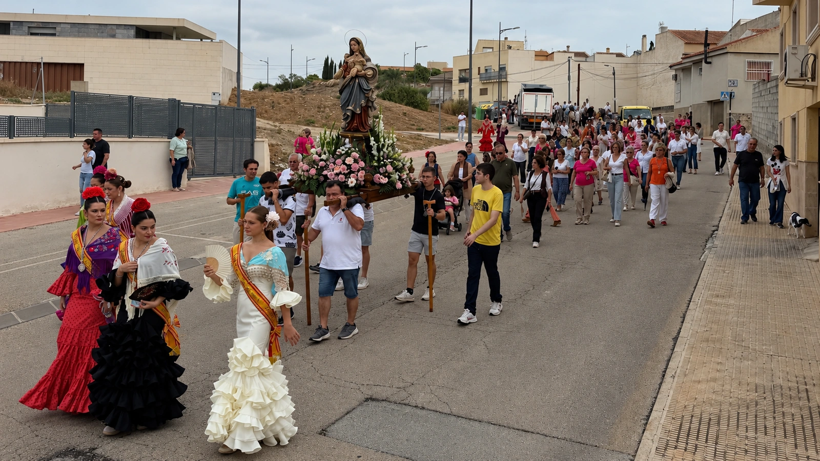 Vecinos acompañan las andas de la Virgen del Rosario por una calle de La Algaida