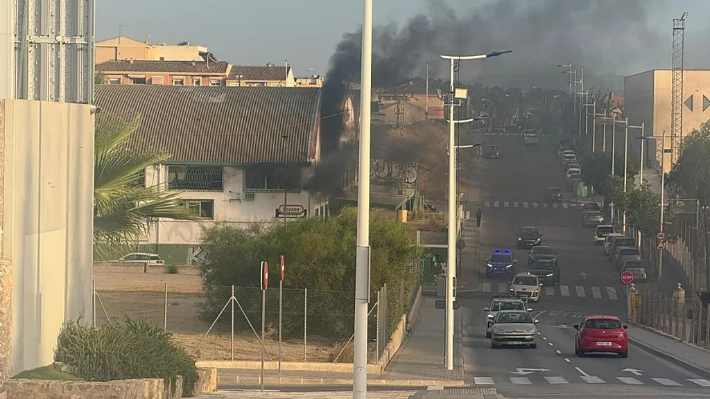 Columna de humo negro durante el incendio en unas naves sin uso de la avenida Valencia de
