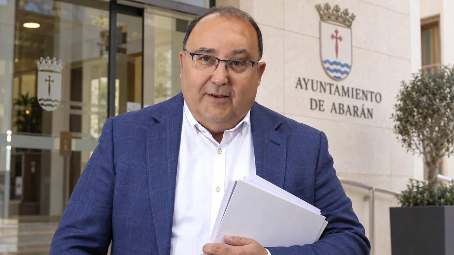 Adrián Carrillo ante el Ayuntamiento de Abarán con documentación del proceso de oposiciones anulado
