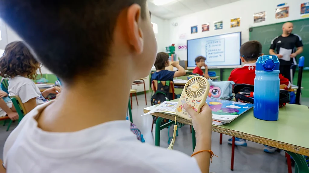 Alumno con un ventilador de mano en un colegio de Las Torres de Cotillas durante una jorna