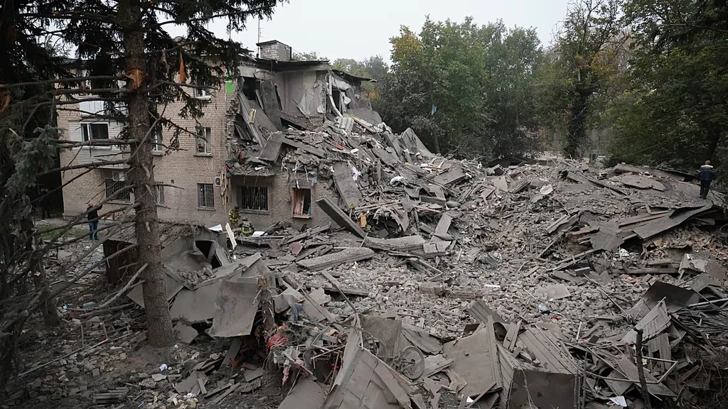 Equipos de rescate retiran escombros de un edificio residencial destruido por un ataque.