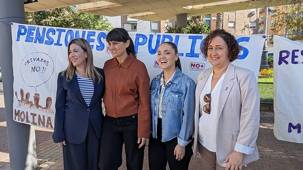 Candidatas del PSOE ante la pancarta de la plataforma de pensionistas de Molina de Segura