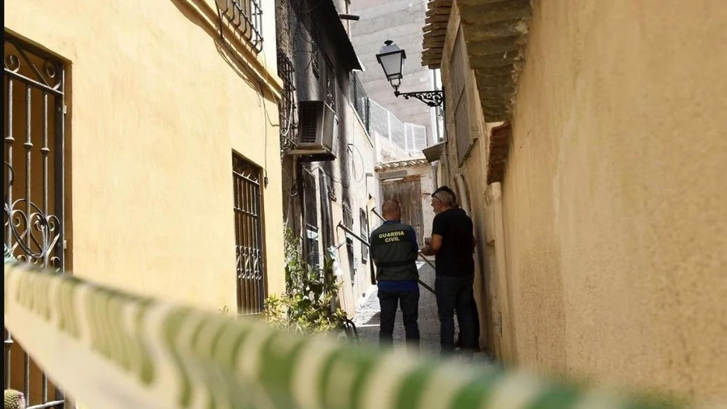 Agentes de la Guardia Civil en el callejón de acceso a la vivienda incendiada en Ricote