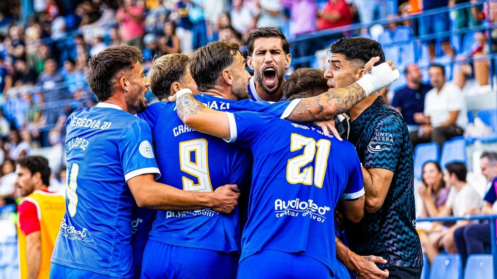 Jugadores del UCAM Murcia celebran un gol abrazados ante la grada