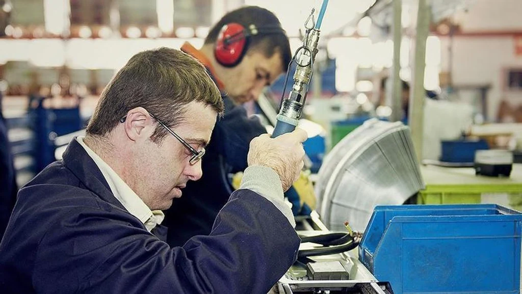 Trabajadores en una línea de montaje en la imagen institucional del programa Empleo con Apoyo