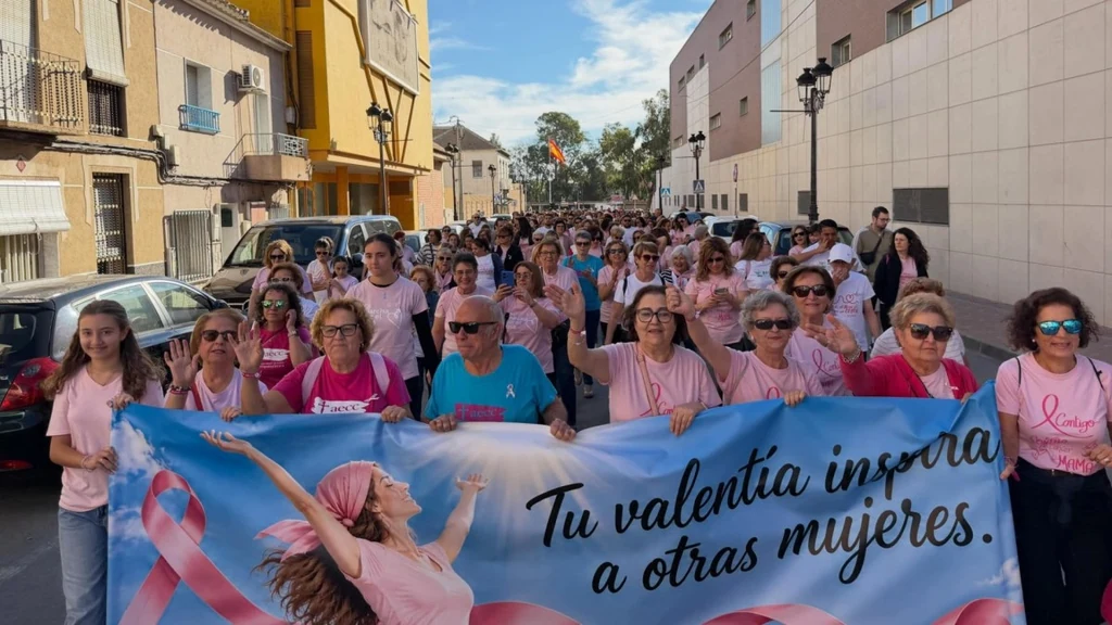 Participantes vestidas de rosa encabezan una marcha contra el cáncer de mama tras una pancarta con el lema 'Tu valentía inspira a otras mujeres'